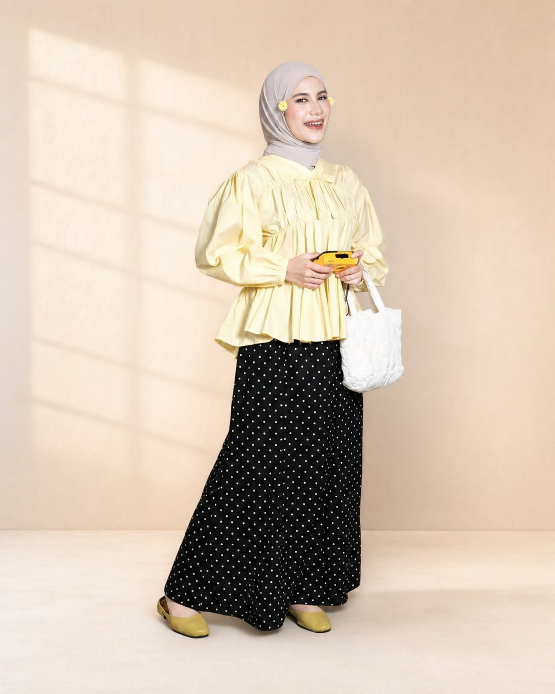Model berhijab mengenakan atasan kuning dan rok polkadot