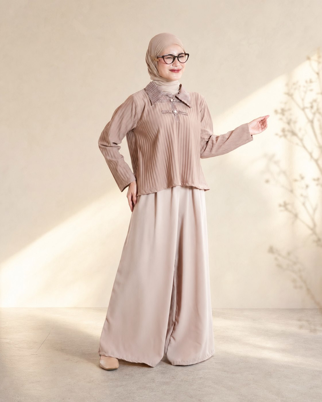 Model berhijab mengenakan busana pleats bernuansa taupe